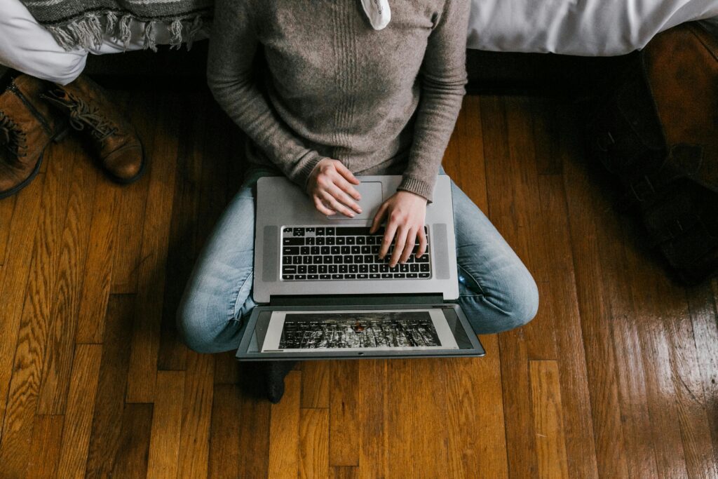 woman in cashmere sweater typing on laptop