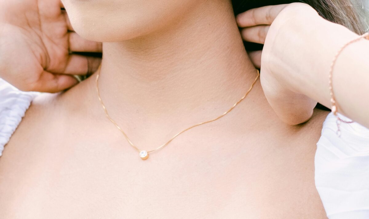 Woman wearing delicate gold necklace and bracelet