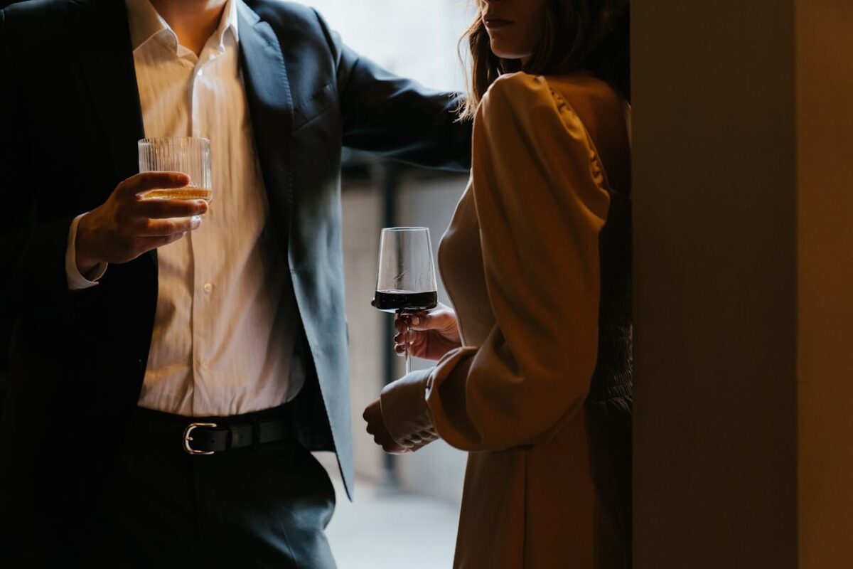 Woman in silk blouse drinking a glass of wine