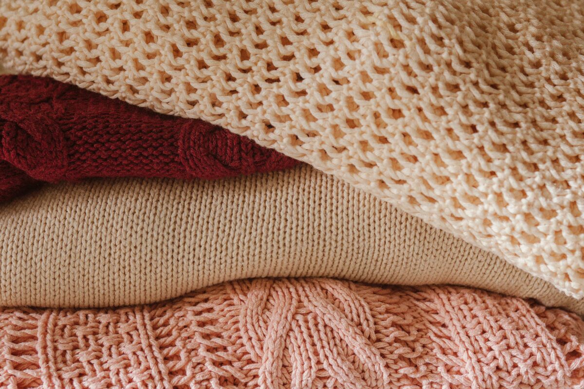 Multiple cashmere sweaters stacked on top of each other