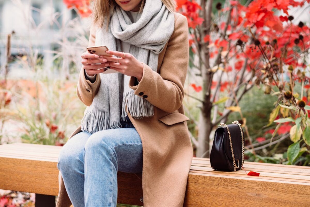 Woman sitting on a park bench wearing a wool coat