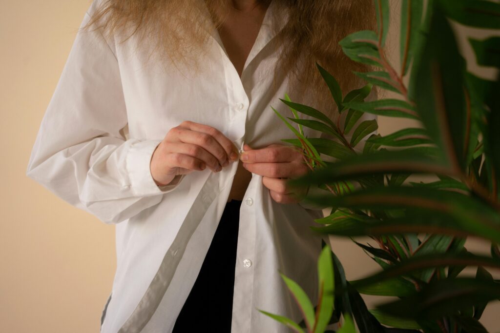 woman buttoning up white shirt