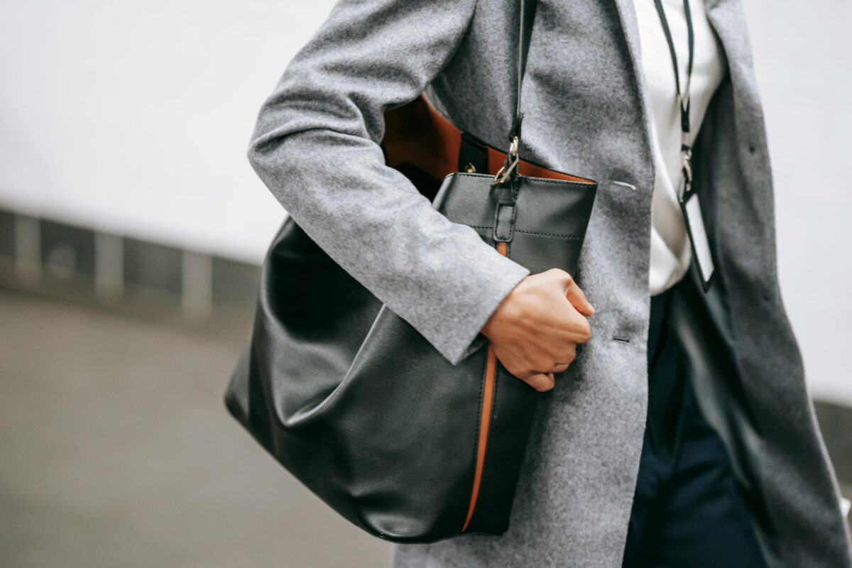 Woman carrying black leather tote bag