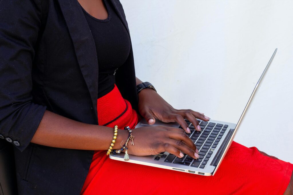 Woman wearing a black blazer typing on a laptop