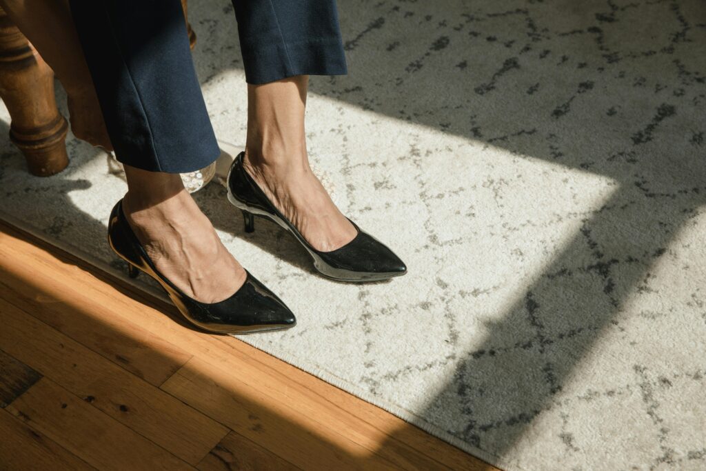 Woman in dark straight leg trousers in black heels