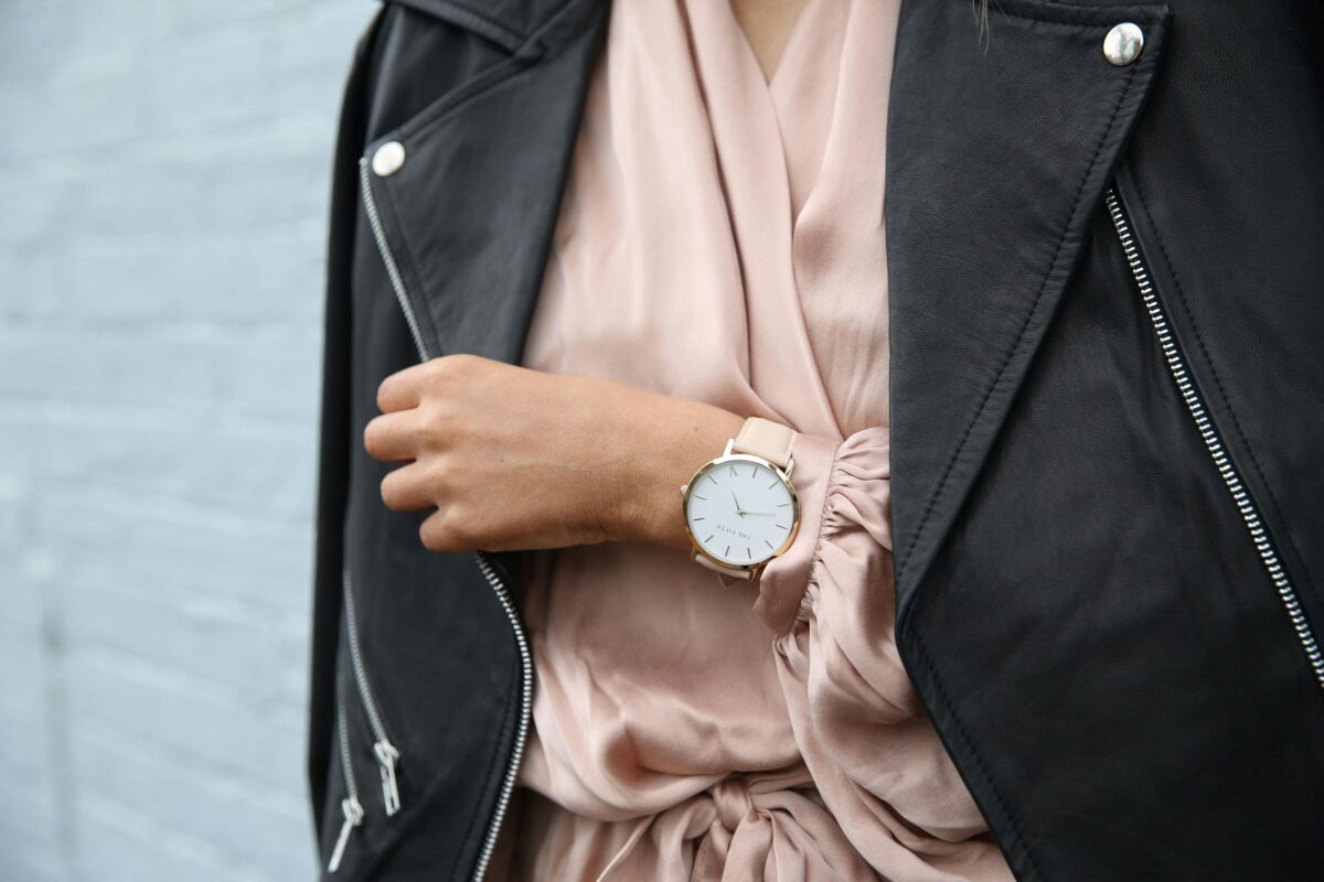 Woman in silk shirt, leather jacket, wearing a chic minimalist watch