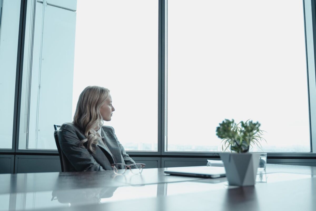 Woman wearing a suit waiting at a conference room table